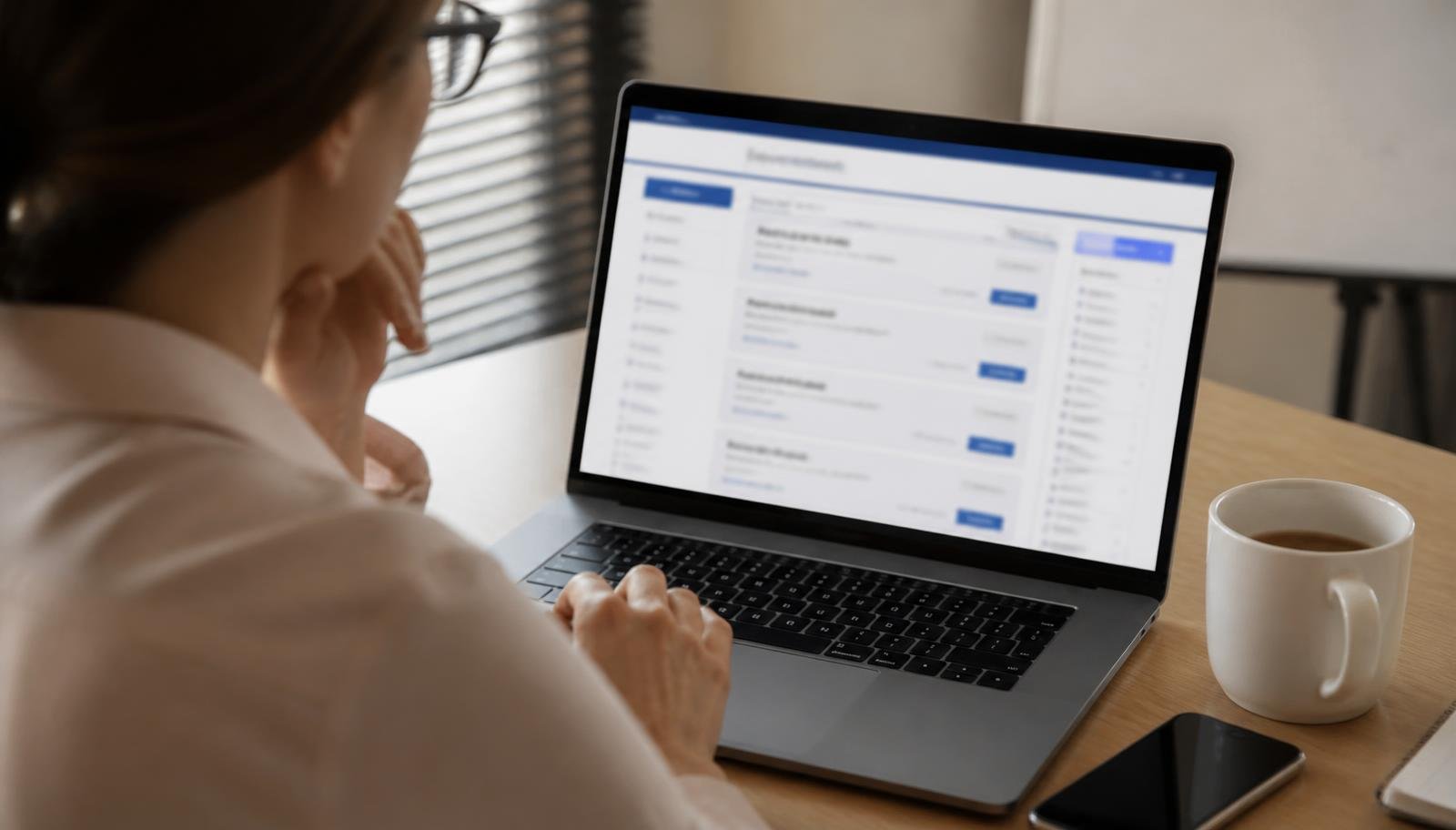 Busca por vagas de home office em portal de emprego Pessoa pesquisando anúncios de vagas de emprego em um notebook sobre mesa de escritório